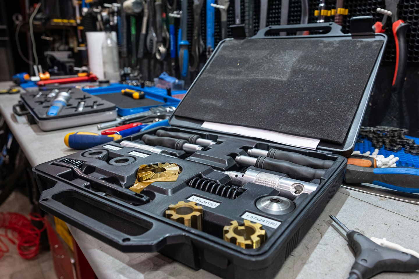 Open bicycle repair toolkit on a cluttered workbench.