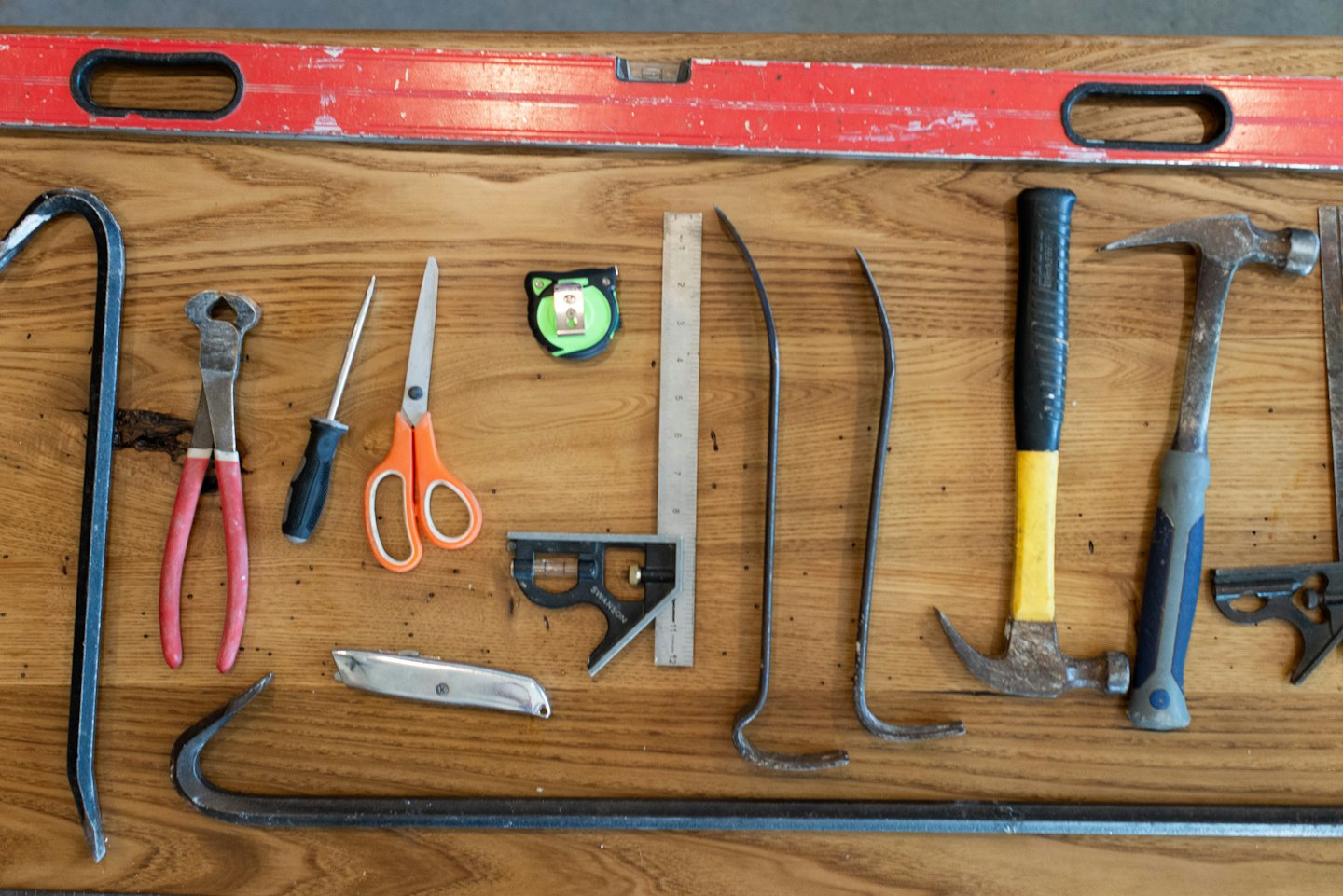 Various carpentry tools laid out on a wooden workbench.